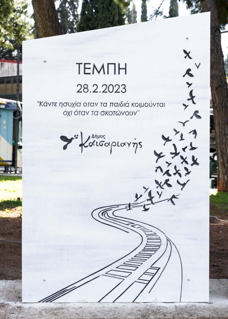 μαρμάρινο μνημείο με σκαλιστά γράμματα χειροποίητα. Τοποθετήθηκε σπό Δήμο Καισαριανής, αφιερωμένο στους νεκρούς των Τεμπών.